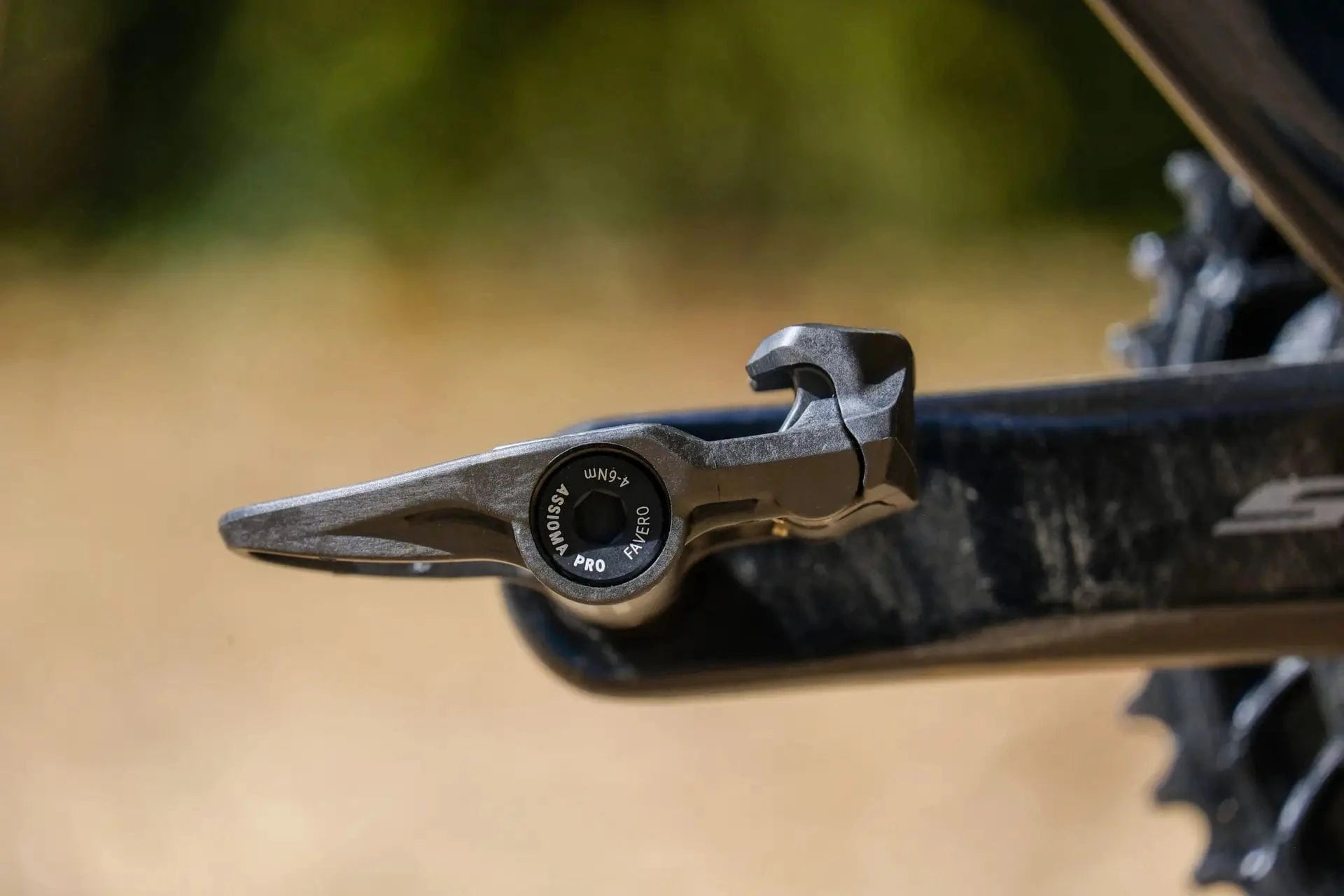 Close-up of the Favero Assioma PRO RS power meter pedal body mounted on a crank arm, showing the sensor and durable construction