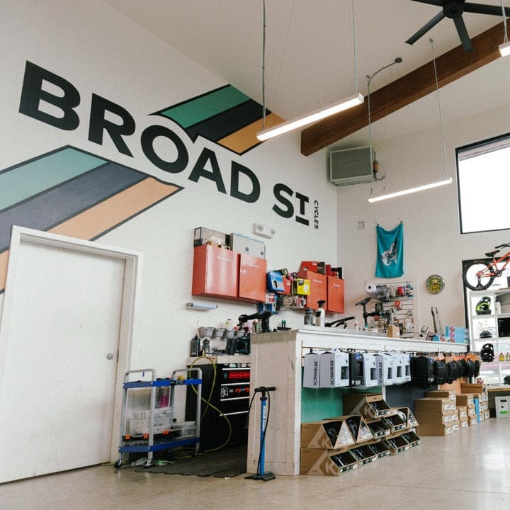 Bicycle store interior with bikes on display and 'Broad St' branding on the wall.