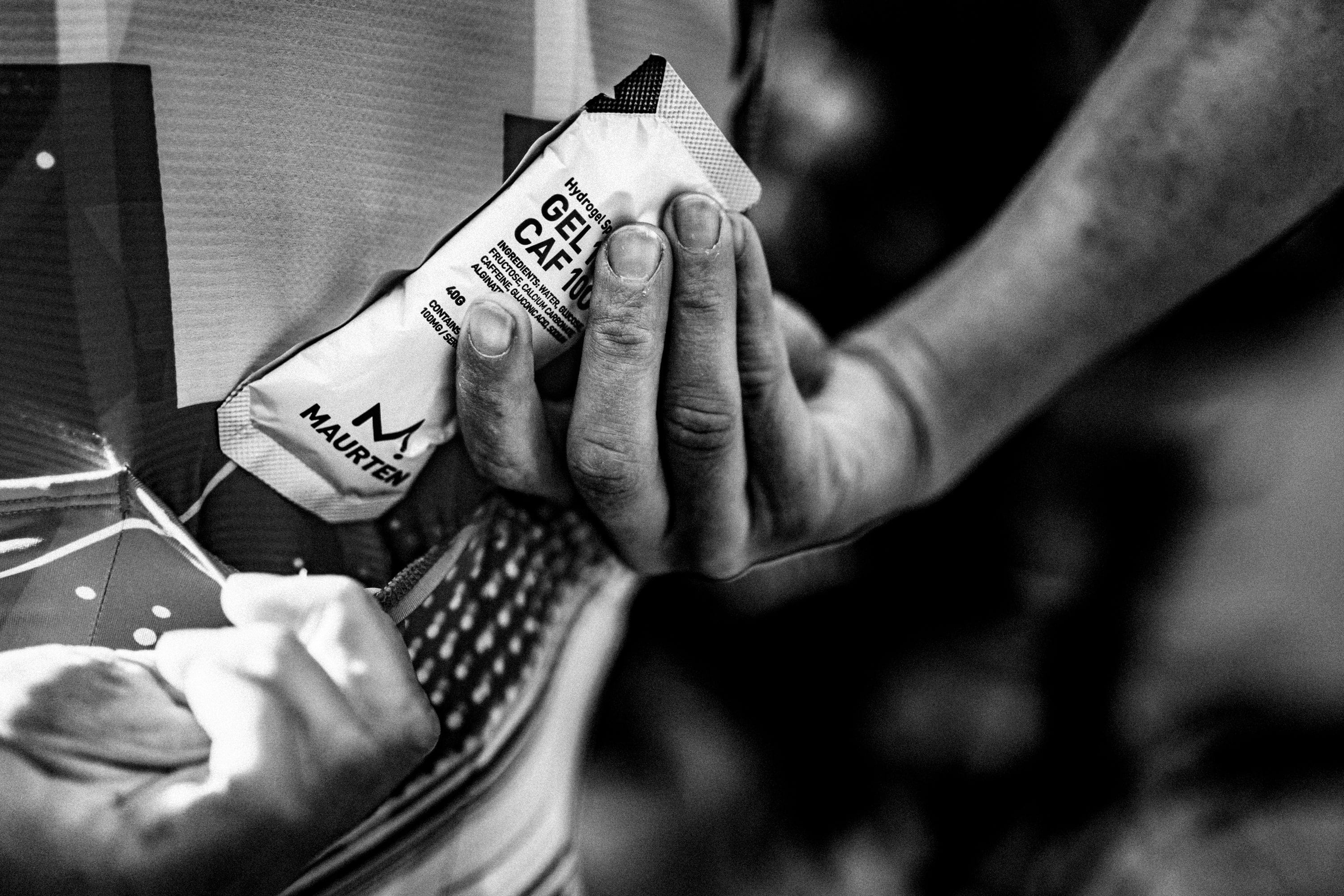 A Maurten gel being inserted into a cyclist's jersey pocket
